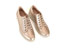 Championes de cuero color dorado con cordones y suela blanca.