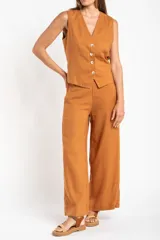 Pantalón de lino color ocre, de corte recto y tiro medio, con lazo de ajuste en la cintura.