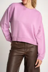 Sweater lila de algodón, corte holgado, con cuello redondo y mangas largas.