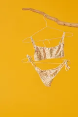 Conjunto de bikini con estampado animal print, compuesto por un corpiño bandeau con breteles finos y una bombacha vedetina con tiras laterales ajustables.
