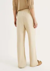 Pantalón negro de tiro alto con cintura elástica fruncida y bolsillos tipo parche redondeados en la parte delantera. El corte es recto y el bajo está doblado.