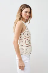 Top tejido crochet color crudo, con cuello halter y espalda descubierta.