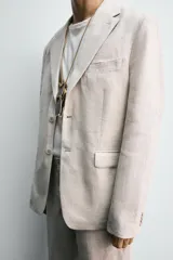 Blazer azul marino de lino, corte regular fit, con solapas de muesca, cierre de dos botones, bolsillo de vivo en el pecho, bolsillos de solapa en la cadera, aberturas en la espalda y puños con botones.
