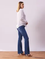 Blusa blanca de manga larga con cuello redondo y detalle de broderie en el canesú.