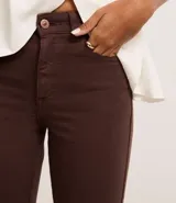 Pantalón flare marrón de tiro alto, confeccionado en sarga de algodón con elastano.