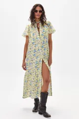 Vestido midi amarillo con estampado floral celeste, de corte recto, con cuello mao y abertura frontal con botones.