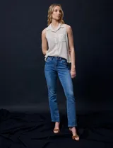 Blusa color crema sin mangas, con cuello camisero, cierre frontal con botones y bolsillo de crochet.