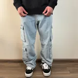 Pantalón jean celeste de corte cargo con bolsillos laterales y corte holgado.