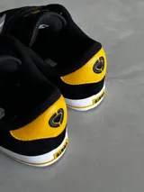 Championes de skate Circa modelo AL 50, color negro con detalles en amarillo y suela blanca.