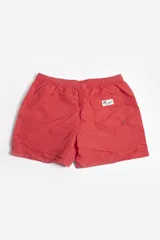 Short de baño liso color azul con cintura elástica ajustable con cordón, bolsillos laterales, tela ligera de secado rápido, suspensor interno y logo estampado.