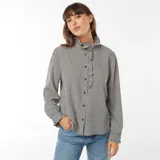 Camisa de manga larga con estampado vichy en blanco y negro, cuello alto con volantes y cierre frontal con botones.