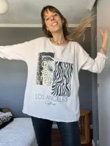 Remerón de manga larga color crudo con estampado frontal de un recuadro con animal print de leopardo y la palabra "LOVE" en letras blancas, y un recuadro con estampado de cebra.