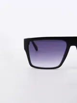 Lentes de sol negros con marco rectangular y lentes degradadas de negro a transparente.