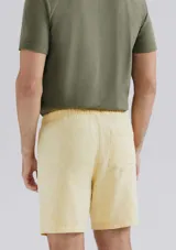 Bermuda verde de tela texturizada con cintura elastizada y cordón de ajuste.