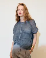 Remera celeste de lino y ramio, con corte boxy, manga japonesa, cuello mao, media cartera con broches metálicos y bolsillo plaqué con efecto de tapa.