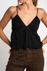 Blusa negra de algodón con breteles finos, escote en V con detalle de encaje y volado en el ruedo.