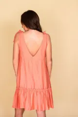 Vestido corto color salmón, con escote en V, corte musculosa y falda con volados.