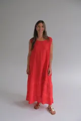 Vestido largo rojo de lino italiano con corte acampanado y detalle de broderie en el ruedo.