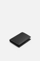 Billetera vertical negra de cuero texturizado con compartimento para billetes y tres ranuras para tarjetas en cada lado.