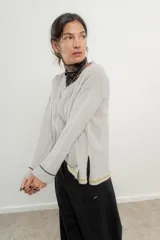 Sweater de punto gris con cuello en V y ribetes en contraste.