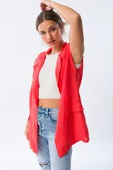 Chaleco largo color rojo coral, sin mangas, con solapas y bolsillos laterales. Confeccionado en lino.