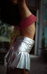 Minifalda plateada de efecto metalizado con cintura ancha y volados en el ruedo.