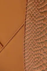 Cartera color marrón con textura símil piel de serpiente en los laterales y las asas. Tiene cierre superior, correa ajustable y herrajes metálicos.