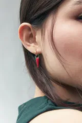 Aros dorados tipo argolla con dije colgante en forma de ají rojo y verde.