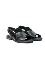 Sandalias bajas de cuero negro con textura tipo cocodrilo, puntera descubierta y talón cubierto con tira ajustable.