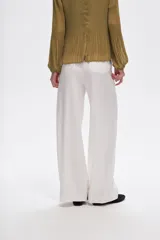 Pantalón de lino color blanco, de corte ancho y tiro alto, con bolsillos laterales y pinzas.