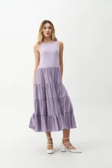 Vestido midi color lila, con cuerpo superior ajustado de punto canalé y falda amplia de tres niveles con textura arrugada.