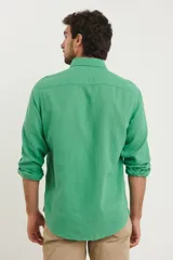 Camisa azul marino de lino y algodón, con cuello abotonado, manga larga con puños enrollados, bolsillo de parche en el pecho y cierre frontal con botones.