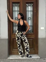 Chaleco negro con escote halter y cierre frontal con botones.