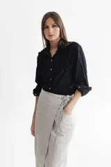 Camisa negra de voile de algodón bordada tipo broderie con apliques de voladitos en el frente, escote mao y cierre con botones de madera.