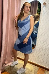 Vestido corto de tirantes finos, con escote en V, confeccionado con paneles de denim en diferentes tonos de azul dispuestos en un patrón de chevron o espiga.