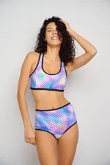 Conjunto de bikini estampado con flores y hojas en tonos celeste, turquesa, rosa y violeta. El corpiño es deportivo con breteles negros y la bombacha es de tiro alto con ribete negro.
