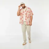 Camisa de manga corta color salmón con estampado de flores blancas, cuello americano y corte recto.