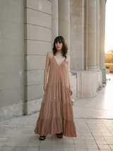 Vestido largo color beige, tipo solera, acampanado con vuelos en la falda y breteles finos.