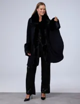 Ruana tejida color crema de la marca Adrienne Vittadini, con cuello, delantera y puños con aplique en símil piel. Delantera con abertura central y botón trenca.