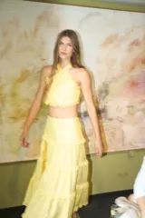 Top halter de lino color crudo, con escote enmarcado por bordes festoneados y tiras cruzadas en la espalda.