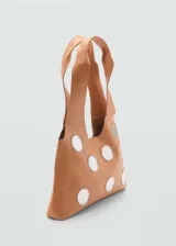 Bolso tipo shopper color marrón claro con apliques de círculos blancos y doble asa corta.