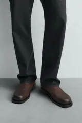 Botín marrón de piel con acabado serraje, cierre de cremallera lateral, plantilla de piel, horma cuadrada y suela a contraste con ligero tacón.