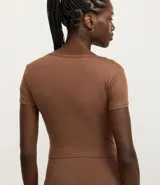 Remera deportiva cropped azul marino, confeccionada en microfibra suave, con escote cuadrado y mangas cortas.