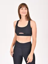 Top deportivo negro con escote redondo y abertura en el centro del pecho.