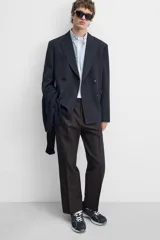 Pantalón de vestir negro de corte recto, con cintura elástica, pliegues frontales, bolsillos laterales y traseros.