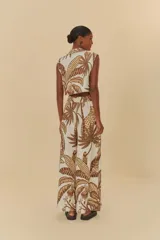 Pantalón ancho con estampado de hojas de palmera en tonos marrón y beige. Tiene cintura alta con cierre discreto y bolsillos laterales.