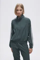 Campera deportiva color gris topo con cierre frontal, cuello alto y tres rayas blancas en las mangas.