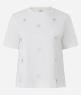 Remera blanca de algodón con cuello redondo y manga corta, con pequeños corazones bordados distribuidos por toda la prenda.