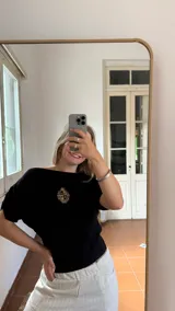 Remera negra de algodón con cuello bote y escudo de Uruguay bordado en dorado.