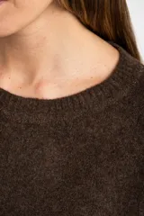 Sweater color marrón claro de tejido de punto, con cuello redondo y mangas largas.